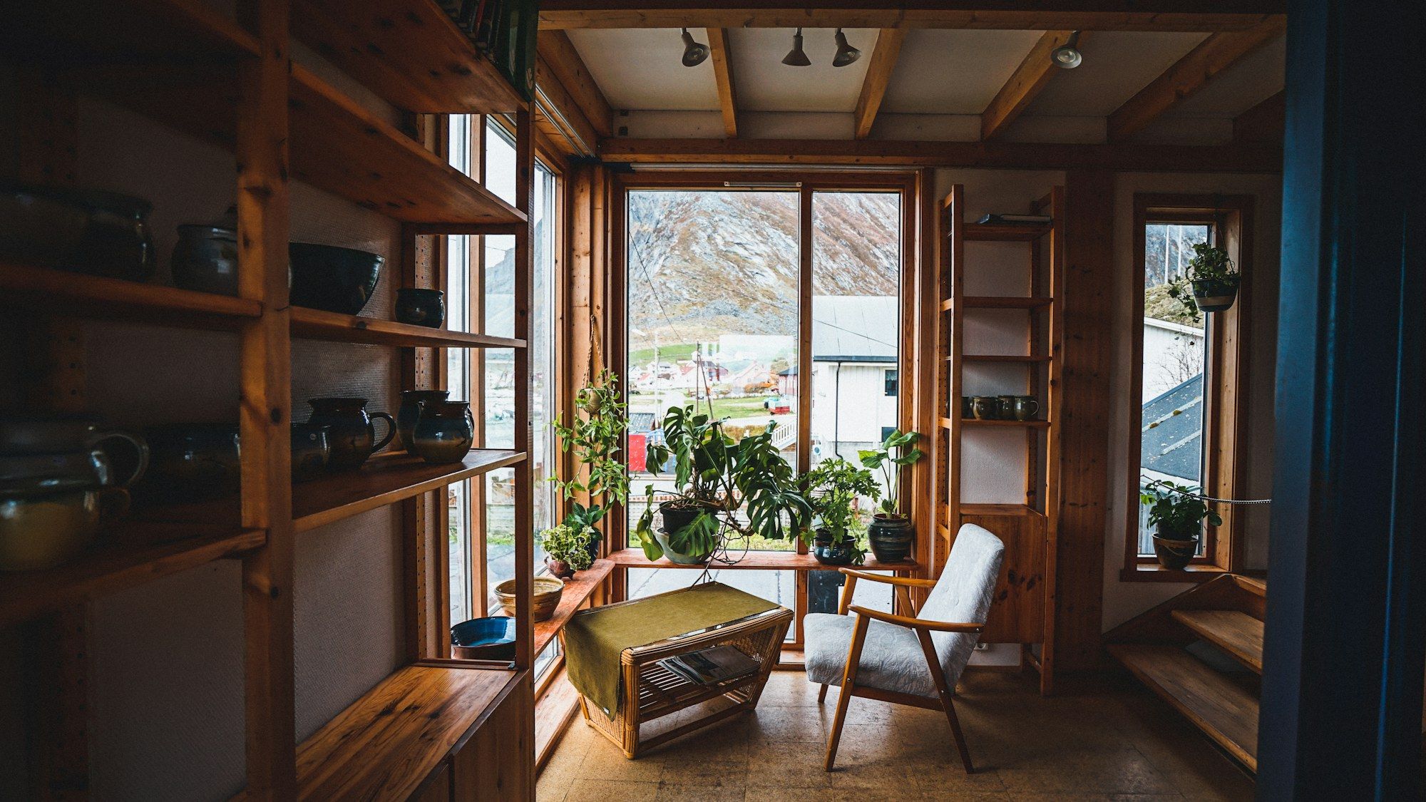 Reading corner with wooden shelves and plants by the window