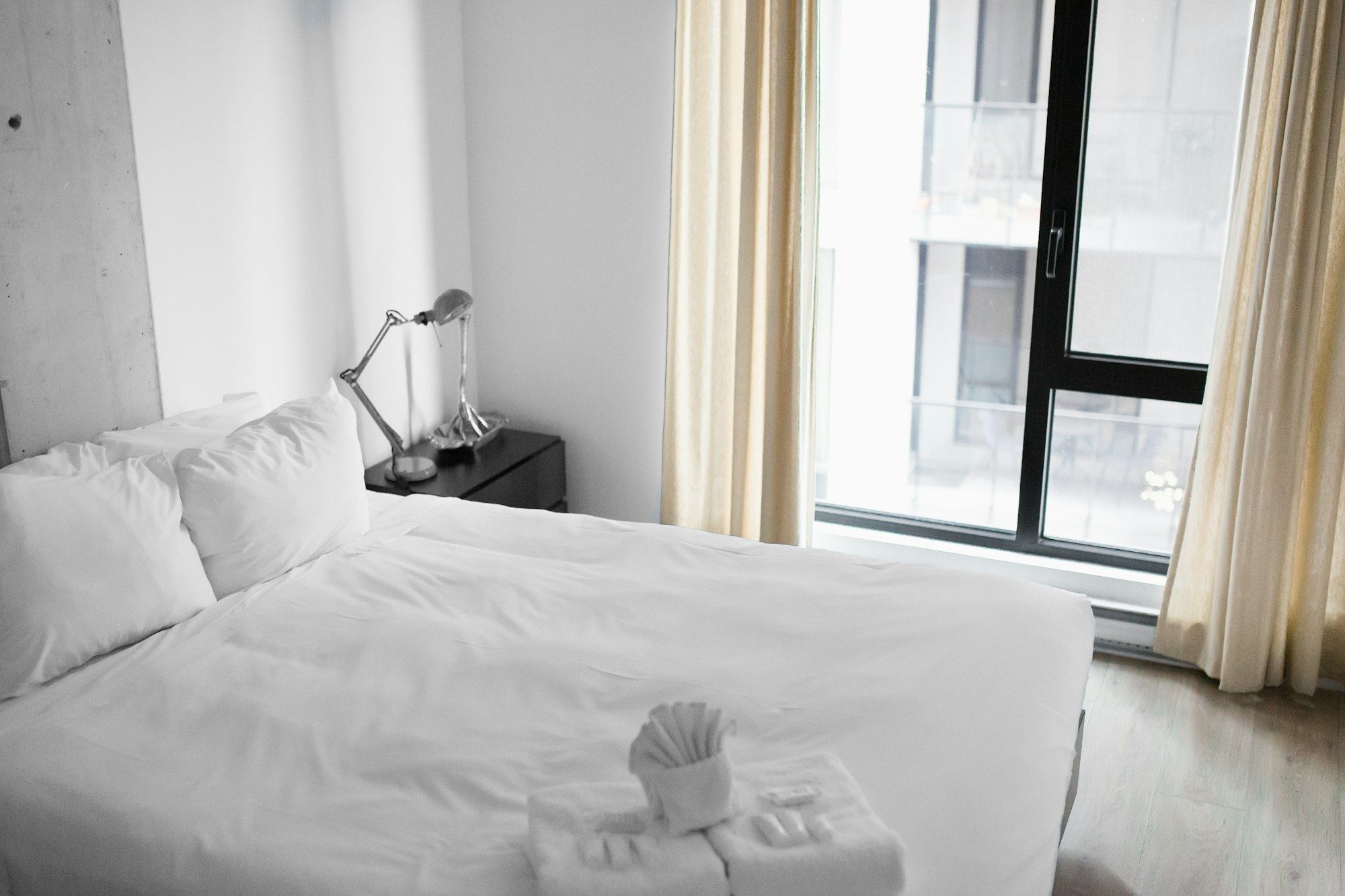Bright room with white linen and a reading lamp